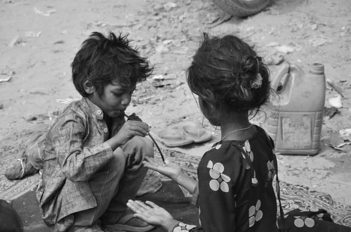grayscale photo of woman in long sleeve shirt sitting on sand